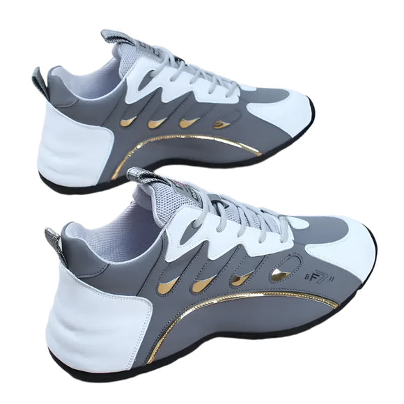 Gray and white sneakers with gold accents on a wooden surface